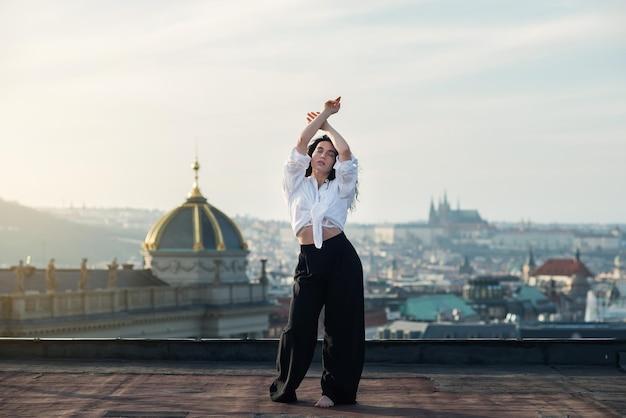 Foto una chica atractiva con una camiseta blanca y un cardigan está en el techo