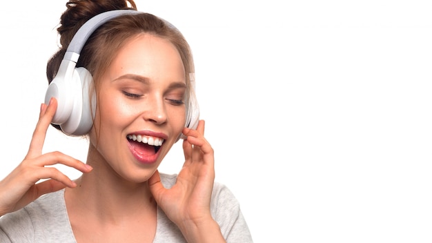 Chica atractiva cantando con auriculares