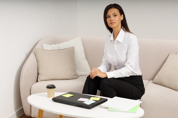 Una chica atractiva con una computadora portátil en una mesa de café