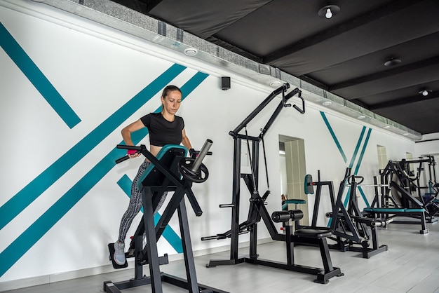 Chica atractiva está haciendo ejercicios en el entrenamiento de levantamiento de pesas y crossfit y levantamiento de pesas