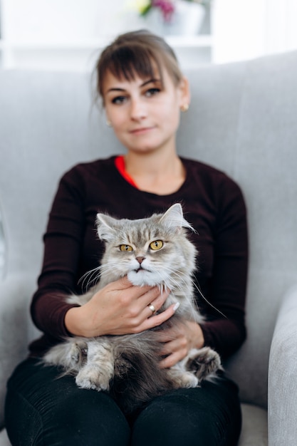 Chica atractiva con un gato en su regazo, vista cercana