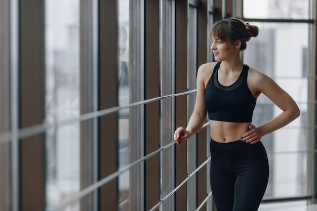 Chica atractiva en el gimnasio durante yoga y fly yoga, posando y luciendo bien