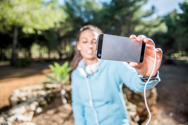 Chica atractiva haciendo un selfie después de su ejercicio en el parque