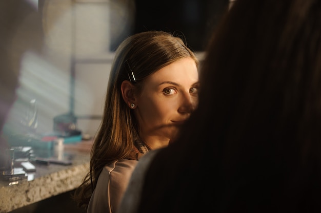 Foto chica atractiva joven sentado en el salón de belleza.