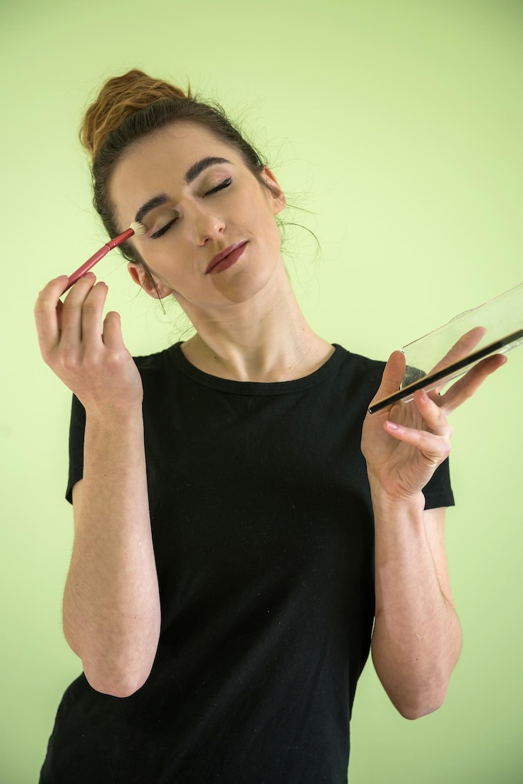 Foto chica atractiva con pinceles de maquillaje aislado en verde. concepto de belleza y salud