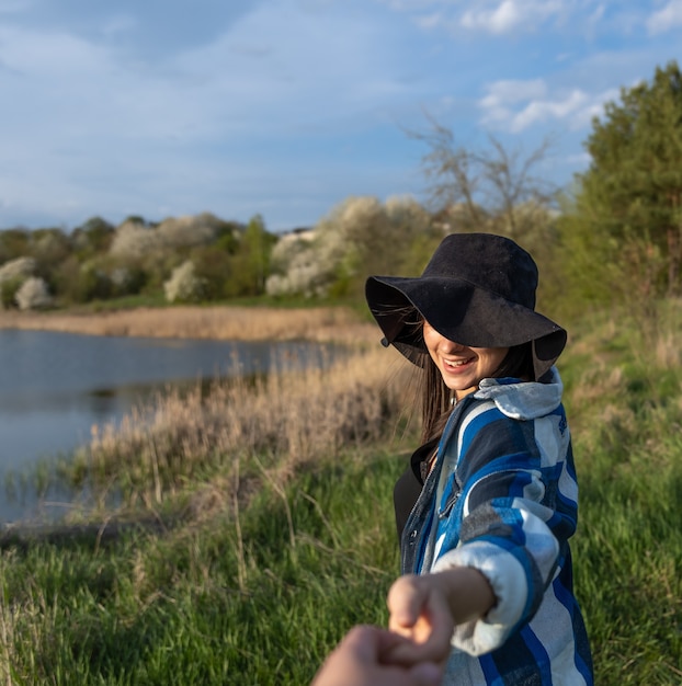 Foto chica atractiva con un sombrero al atardecer en un paseo por el lago