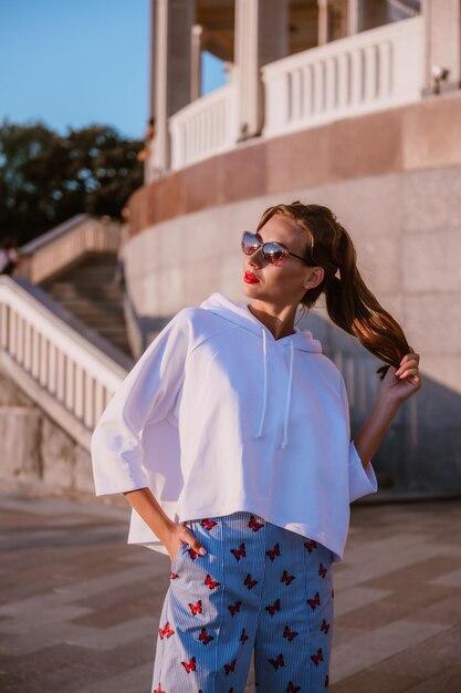 chica atractiva con traje de verano y gafas de sol descansa en el resort