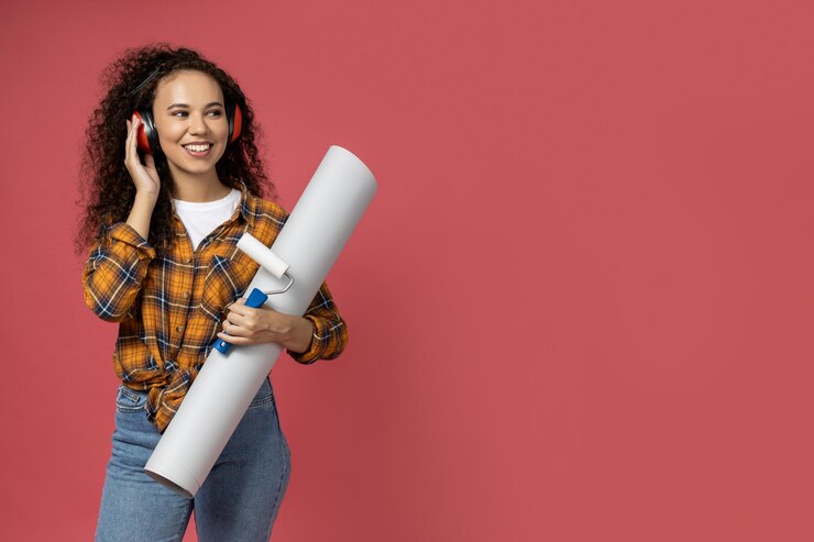 Una chica con auriculares de construcción y con un papel en las manos.