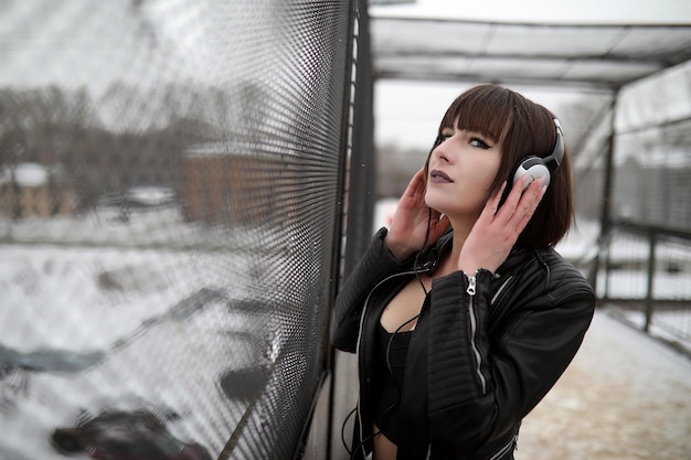 Chica en auriculares escuchando música al aire libre