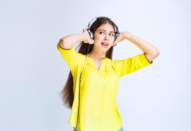 Chica con auriculares manteniendo la calma y disfrutando de la música.