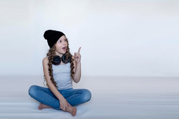 Chica con auriculares muestra un dedo en el fondo