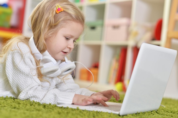 Chica con auriculares usando laptop