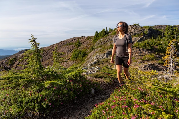 Chica aventurera caminando por el sendero en el paisaje montañoso canadiense