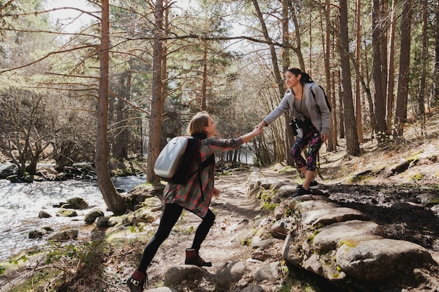 Chica ayudando a su amiga al aire libre