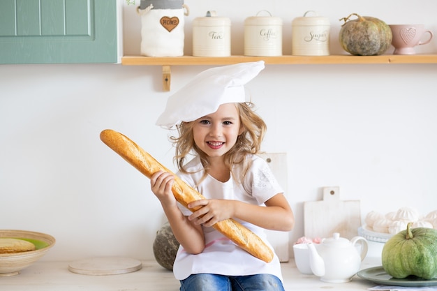 Chica con baguette fresca en la cocina en casa