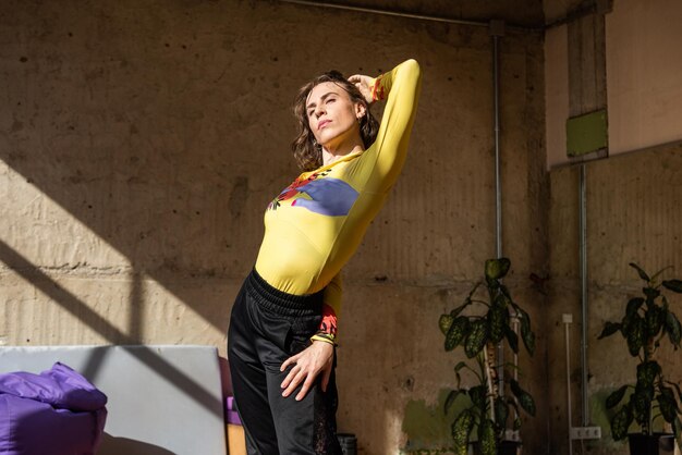 Una chica baila una danza contemporánea en un estudio iluminado por el sol