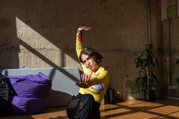 Una chica baila una danza contemporánea en un estudio iluminado por el sol