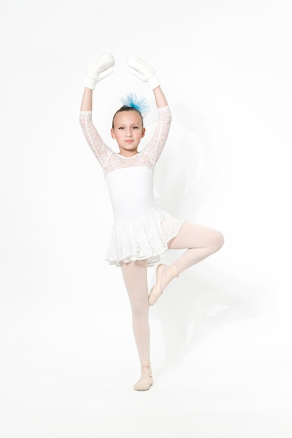 Foto chica bailarina de ballet en falda de tutú de ballet blanco bailando sobre fondo blanco con sombra