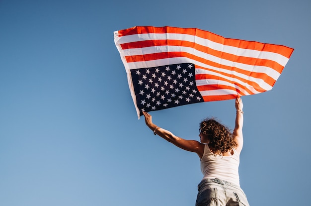 Foto chica con una bandera americana día de la independencia