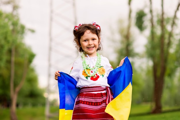 Chica con la bandera de Ucrania. Ella está vestida con una camisa bordada - vestido nacional ucraniano.