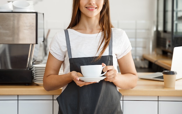 Chica barista trabajando en la cafetería.