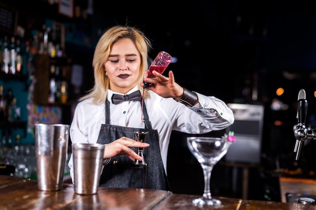 Chica barman crea un cóctel en la brasserie