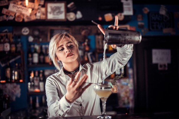 Foto chica barman crea un cóctel en el salón