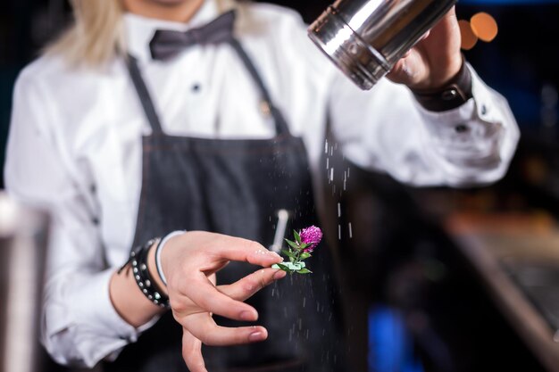 Chica barman formula un cóctel en la brasserie