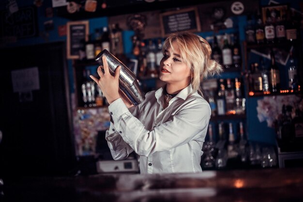 Chica barman formula un cóctel en la brasserie