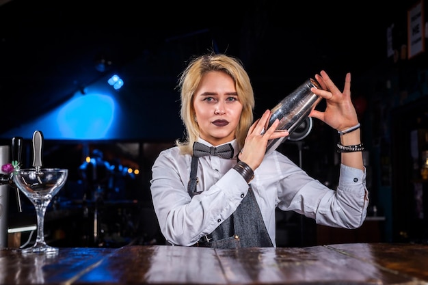 Chica barman formula un cóctel en la brasserie