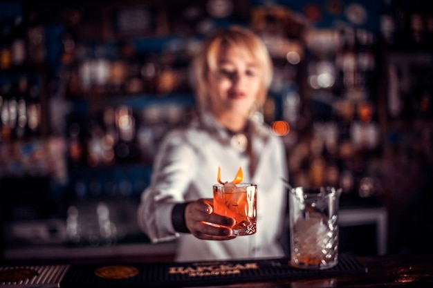 Chica barman formula un cóctel en la taberna