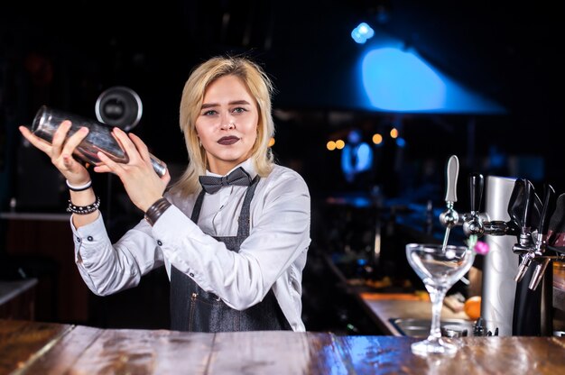 Chica bartender crea un cóctel en la brasserie