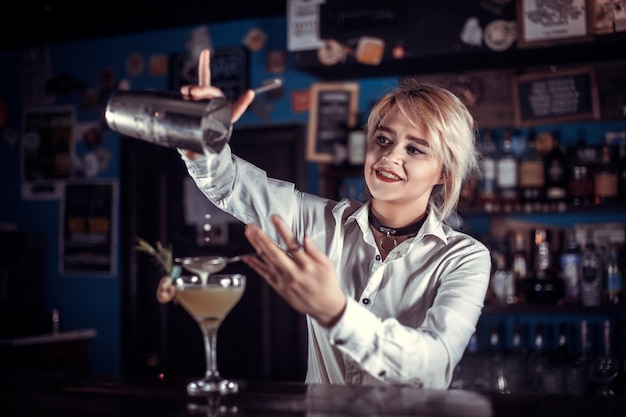 Chica bartender crea un cóctel en el porterhouse