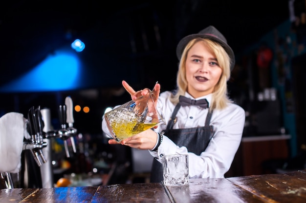 Chica bartender prepara un cóctel en la cervecería