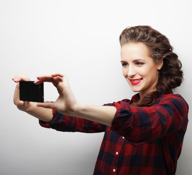 Chica bastante hipster tomando selfie. Joven y feliz.