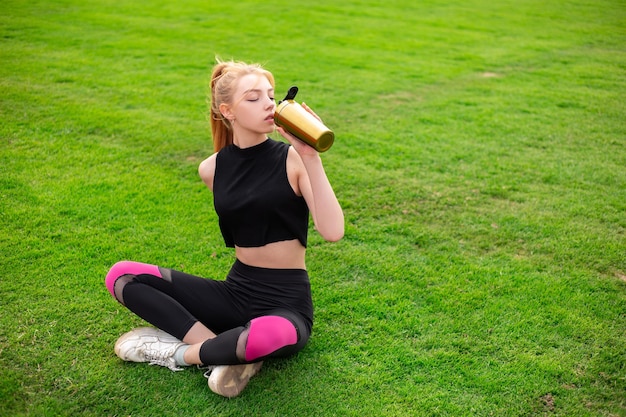 Chica bebe agua después del entrenamiento