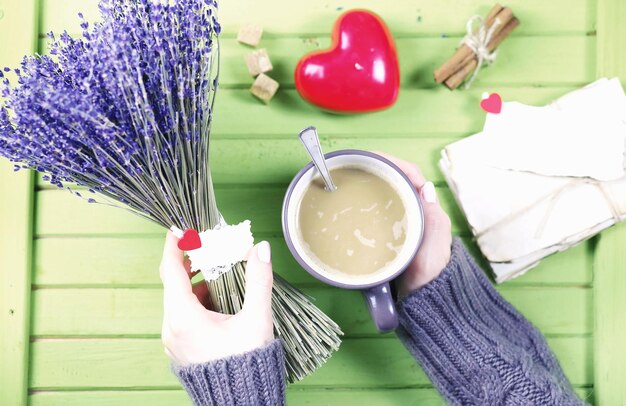 Chica bebiendo café caliente de taza y parece presentado San Valentín