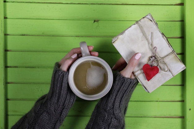 Chica bebiendo café caliente y se ve presentado san valentín