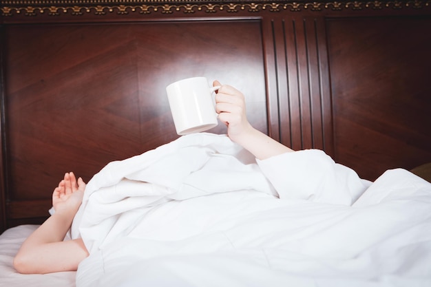 Chica bebiendo café en la cama