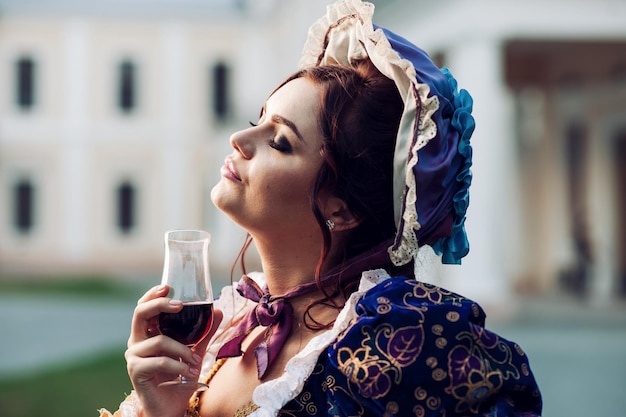 Chica bebiendo vinoMujer joven en traje del siglo XVIII.