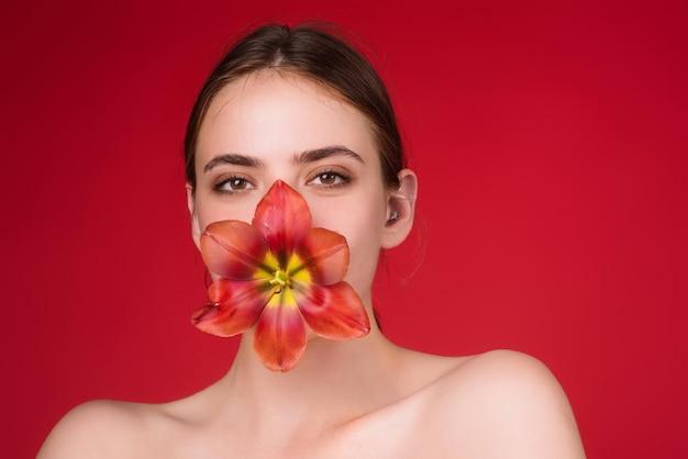 Chica de belleza del día de San Valentín con tulipán en la boca hermosa mujer sensual mantenga tulipanes retrato de estudio o