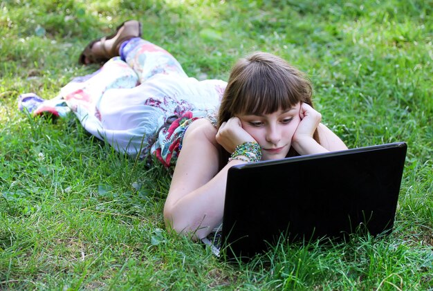 Chica de belleza con laptop al aire libre