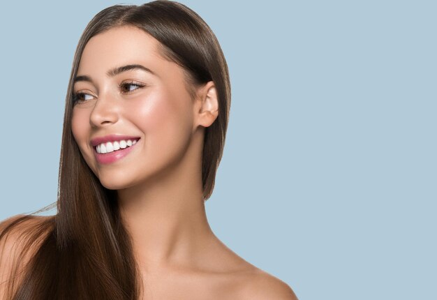 Foto chica de belleza de pelo largo de mujer de pelo liso con labios rosados. fondo de color azul