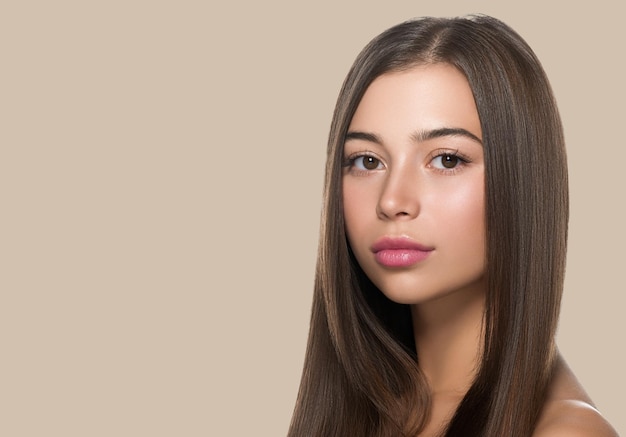 Chica de belleza de pelo largo de mujer de pelo liso con labios rosados. fondo de color Marrón.