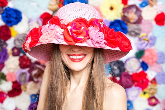 Chica de belleza con sombrero floral sobre fondo de color