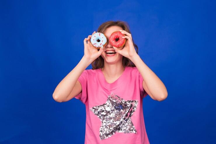 Foto chica de belleza tomando donas de colores.