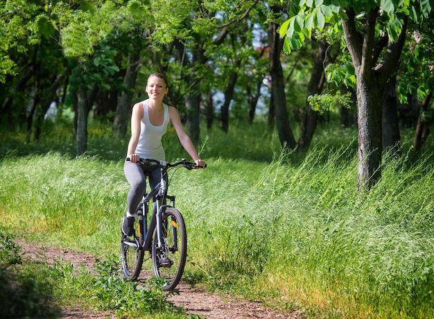 Chica en bicicleta en un bosque