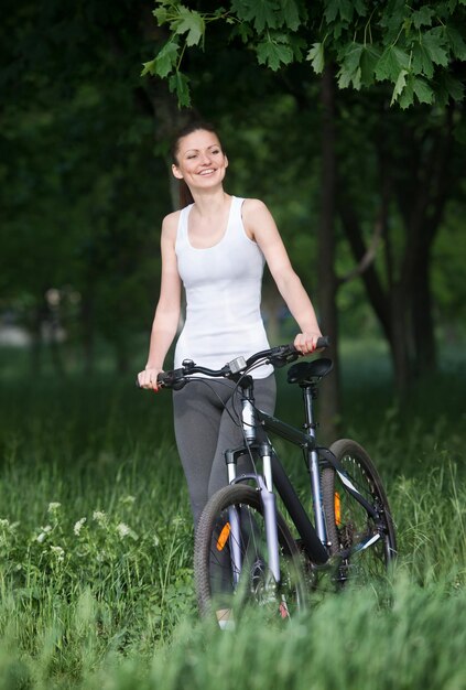 Chica en bicicleta en un bosque