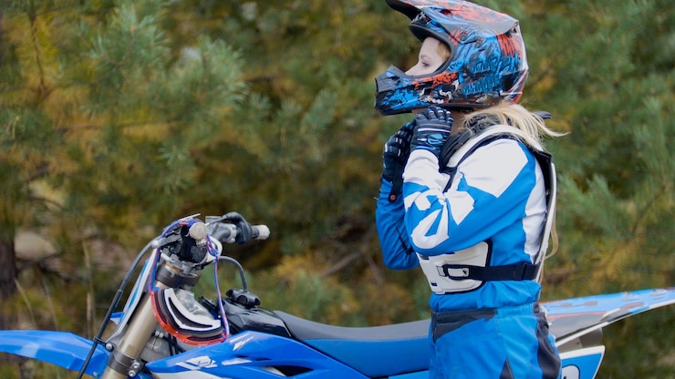 Foto chica en bicicleta lleva un casco mx moto cross racing rider en una motocicleta de tierra
