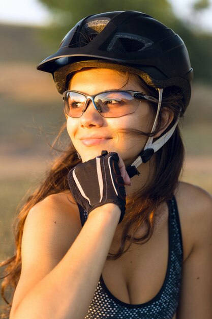 Chica en una bicicleta de montaña en offroad hermoso retrato de un ciclista al atardecer